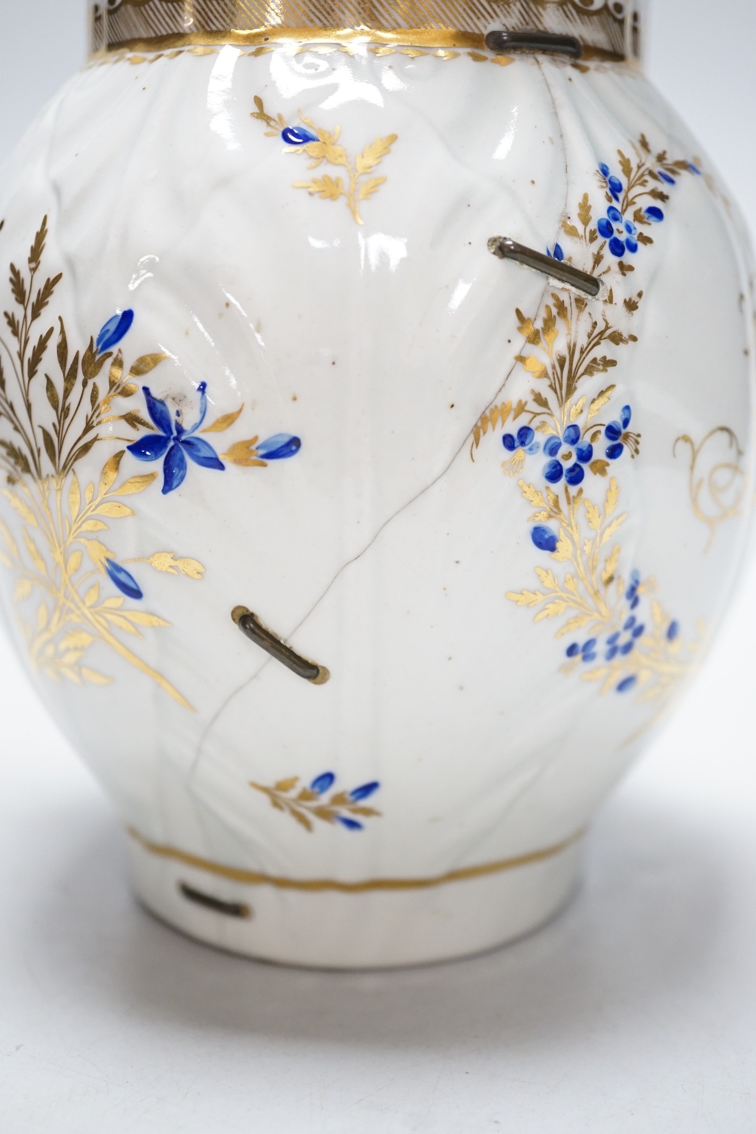 An 18th century Caughley very rare polychrome mask jug, elaboratley painted and gilded with two initials in a dry blue and gilt wreath, Gittins Col., Pictured Caughley Bicentenary Exhibition 1999, with labels, 19cms high